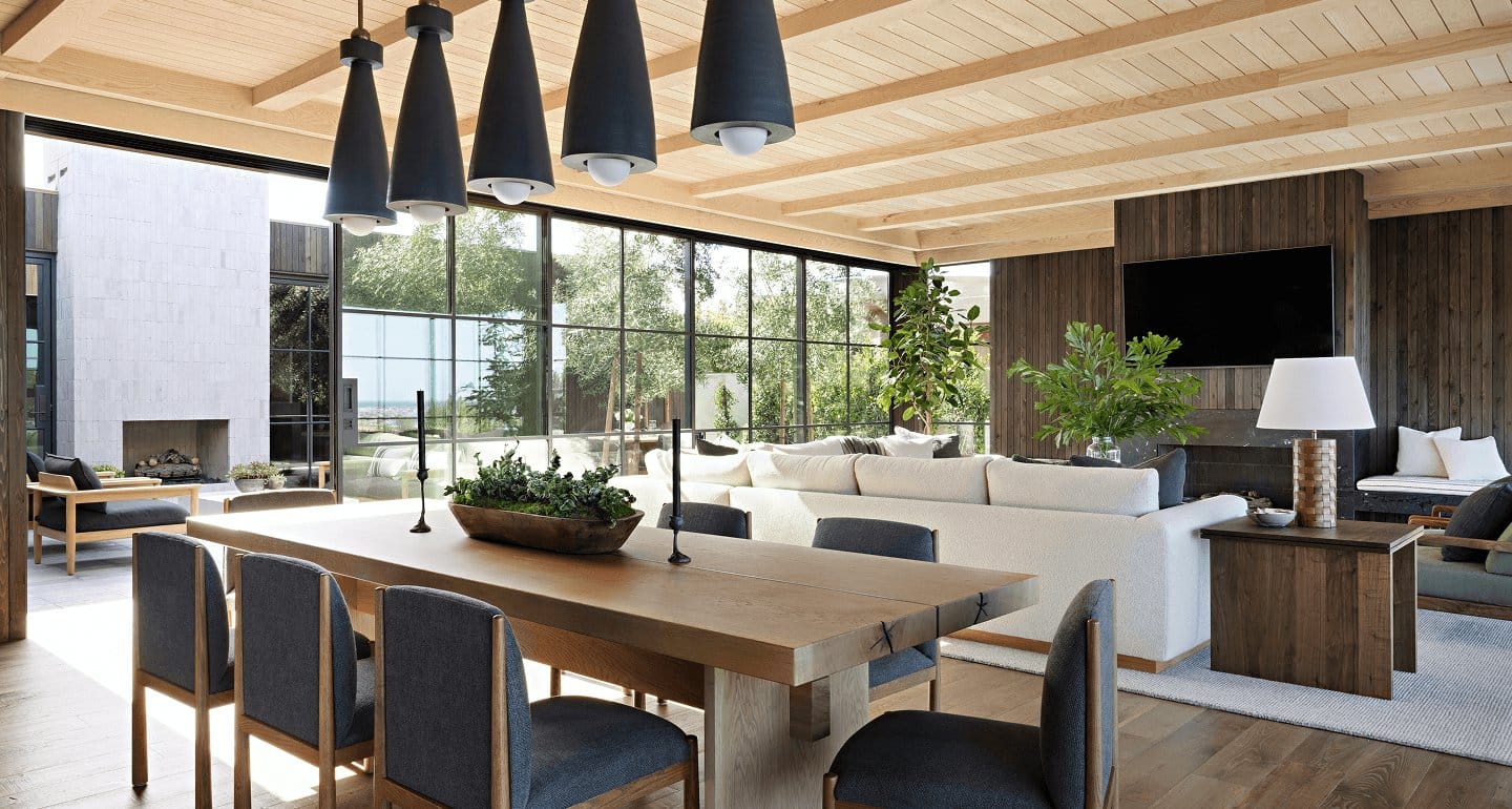 A great room with a full wall of black steel glazing onto a garden.